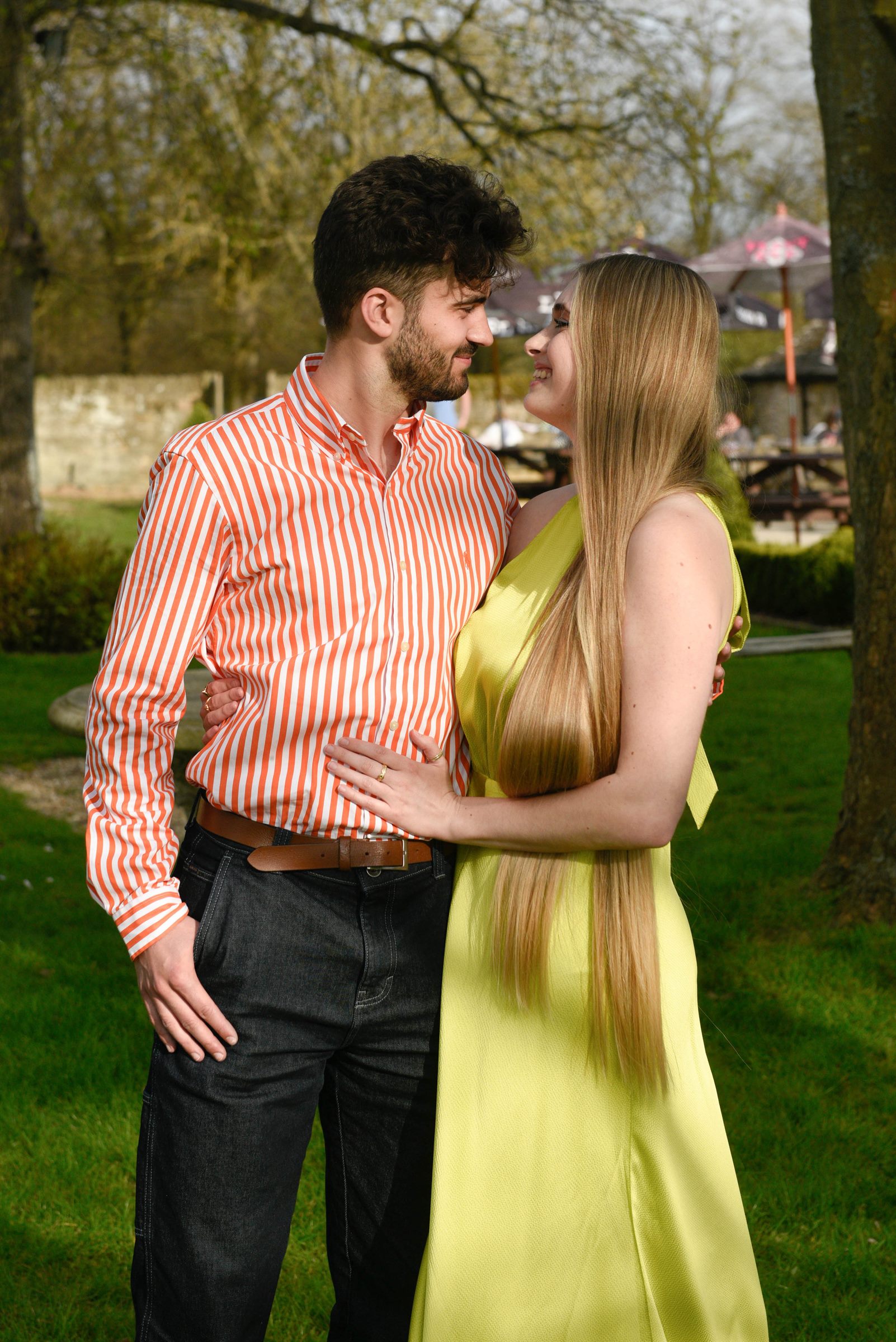 Callum and Celina looking at each other in a sunlit garden